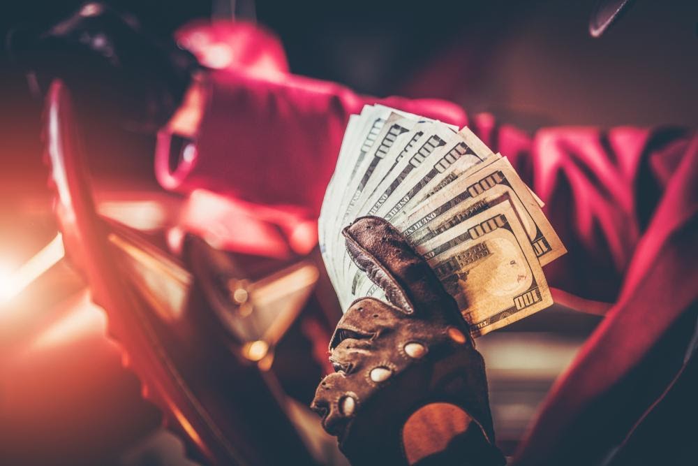 casino drive-in homme montrant des billets de 10 dollars